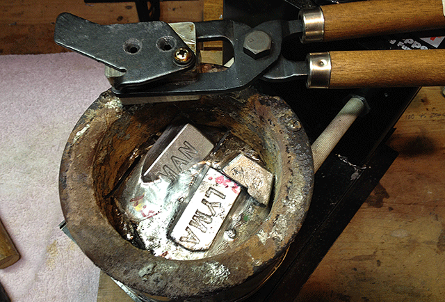 Showing a lead pot with mould resting on rim to warm